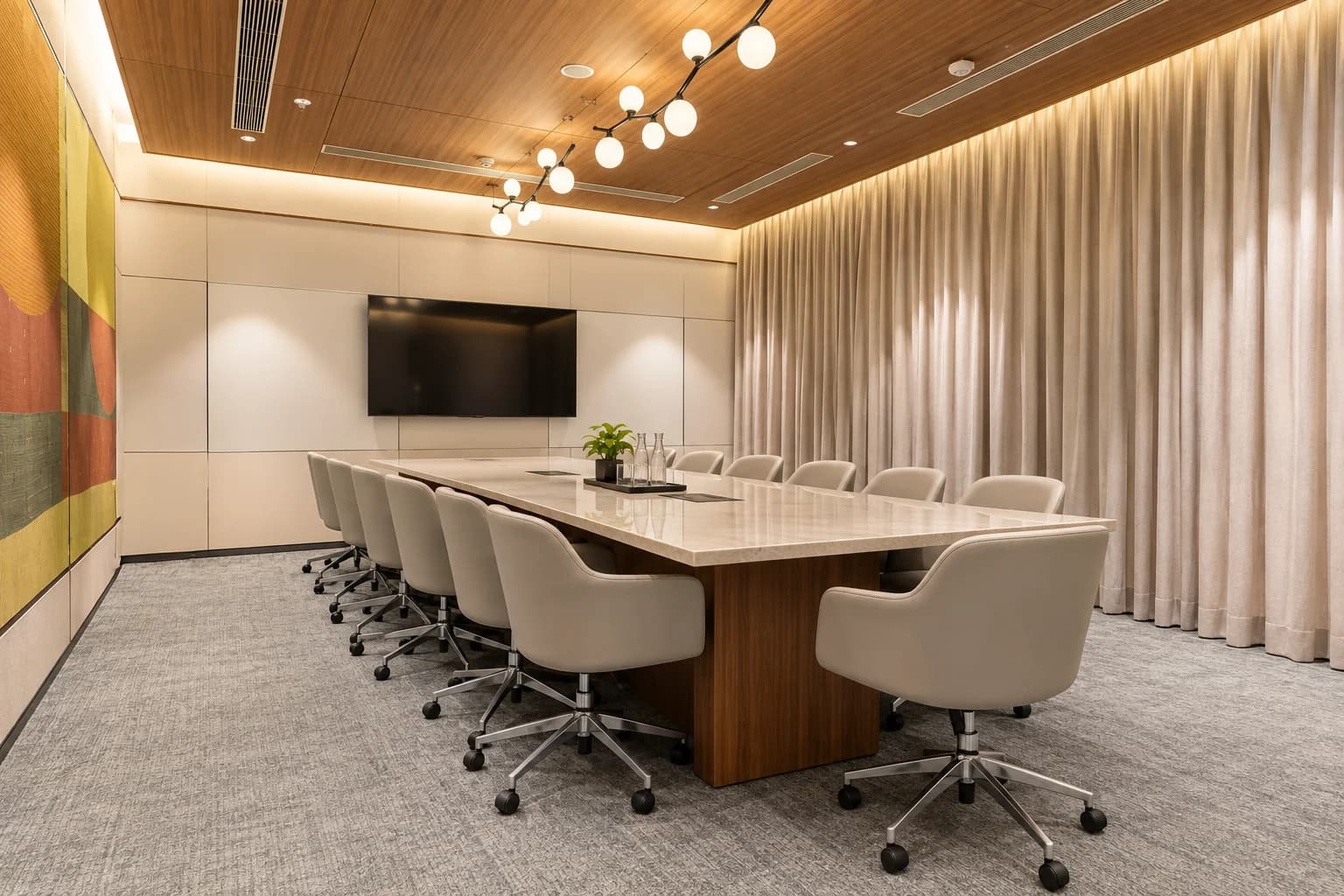 A boardroom at ClayWorks Senate with a stone-topped table, globe pendant lights and a wall-mounted display