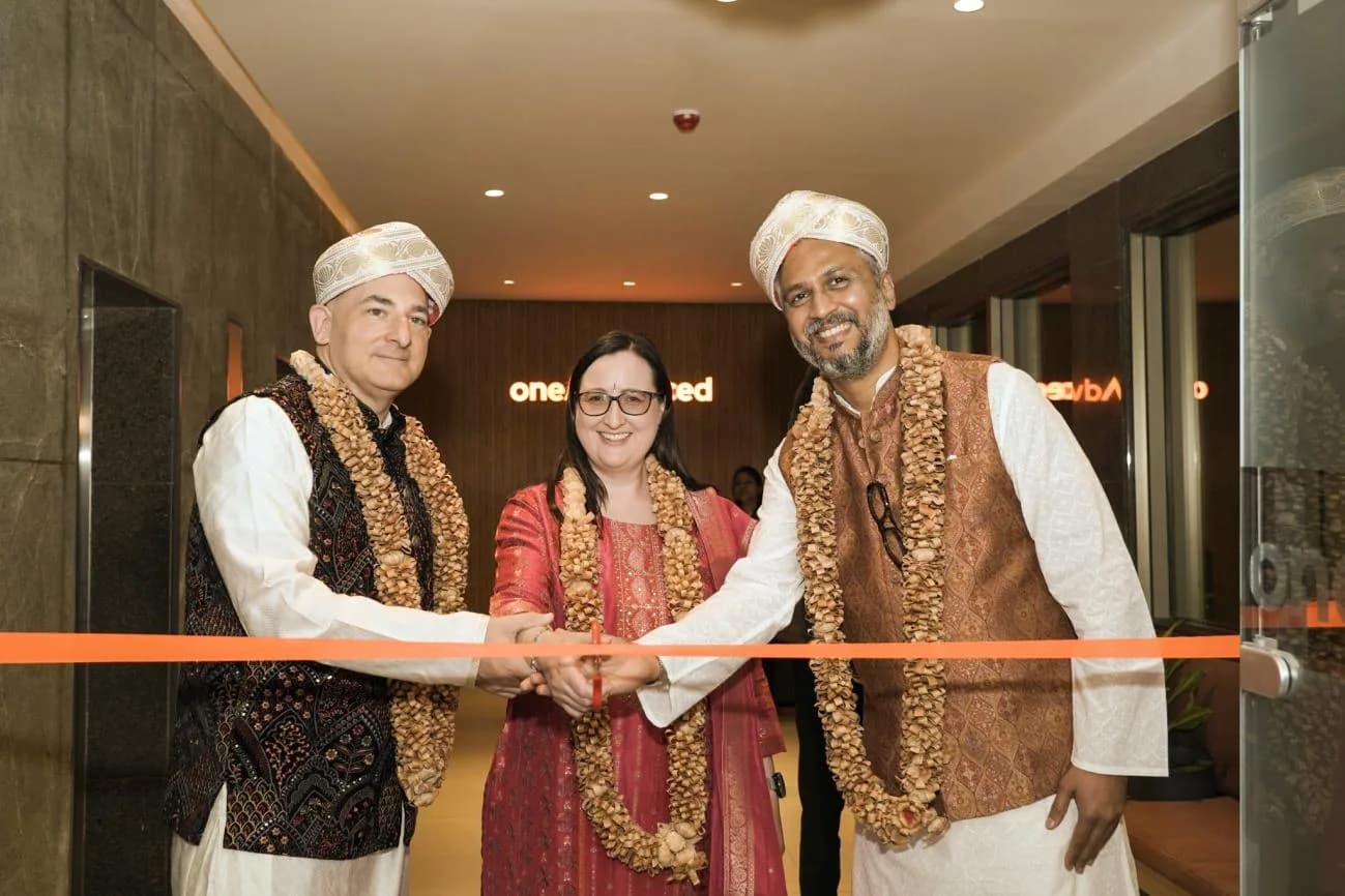 One Advanced's leadership cuts the ribbon at the entrance to its new Bengaluru office at ClayWorks Opus